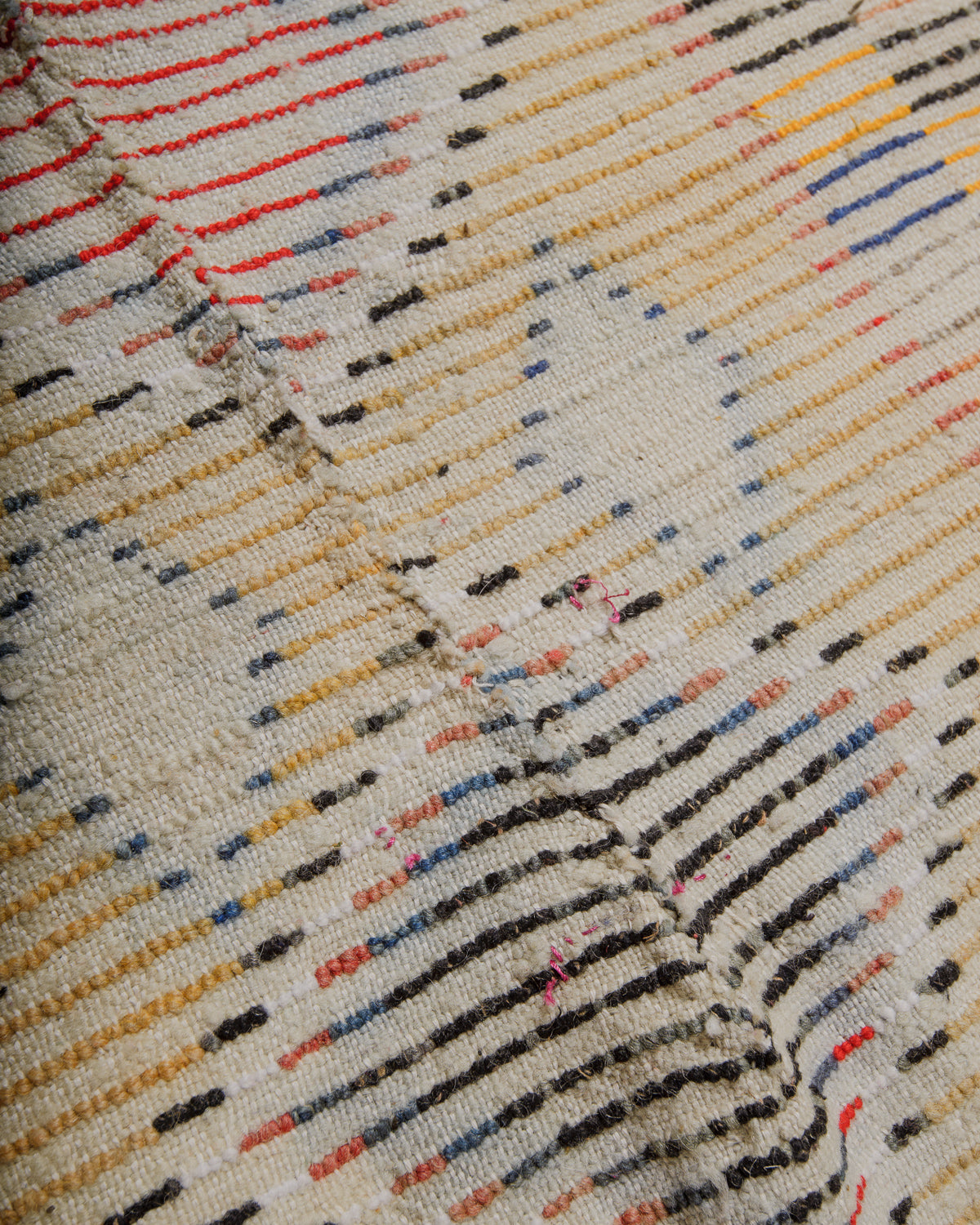 Back of vintage wool rug showing where it has been repaired.